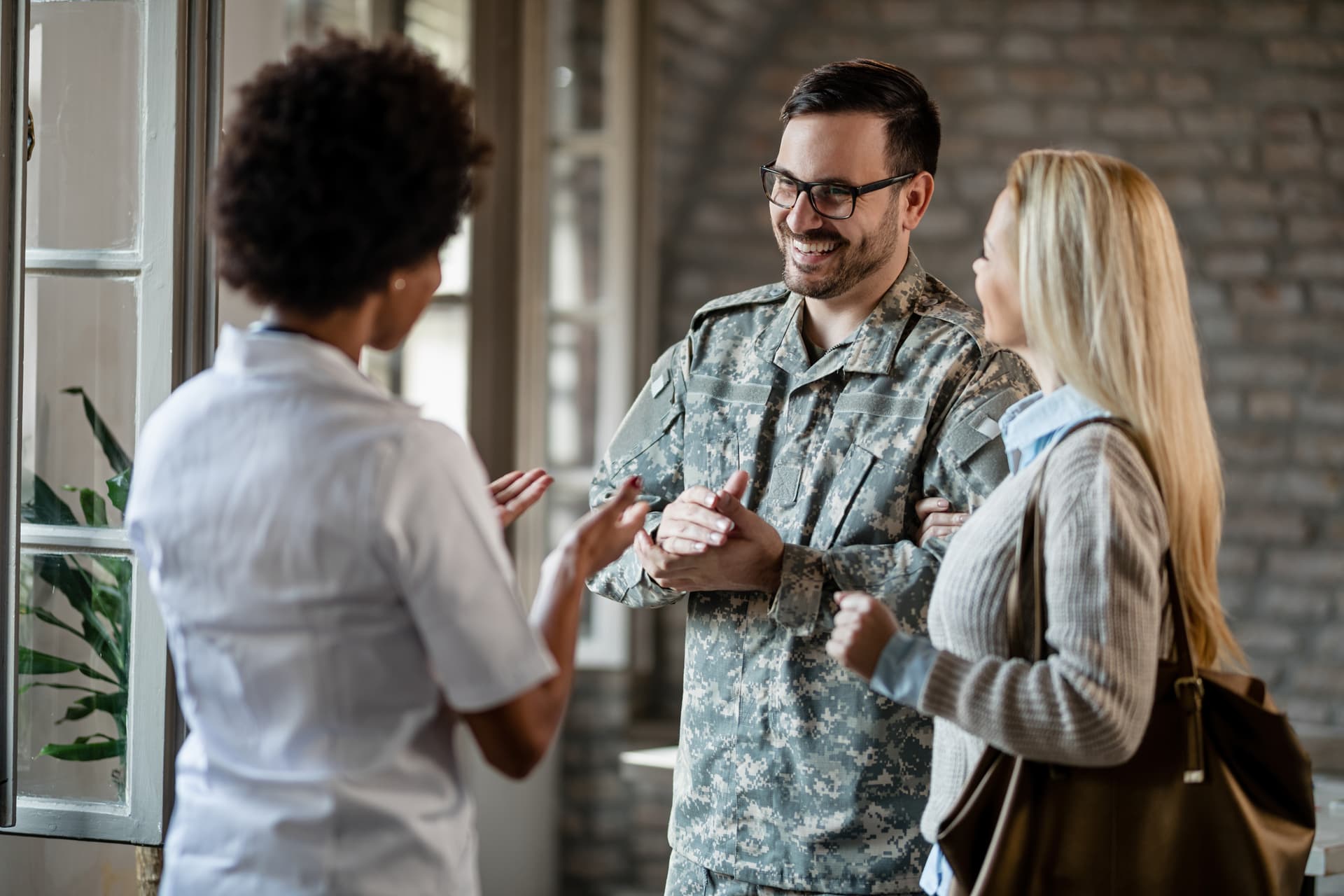 A smiling soldier and their family speaking with a care coordinator — the kind of personal conversation that begins every placement